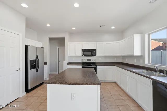 a kitchen with kitchen island a counter top space and refrigerator