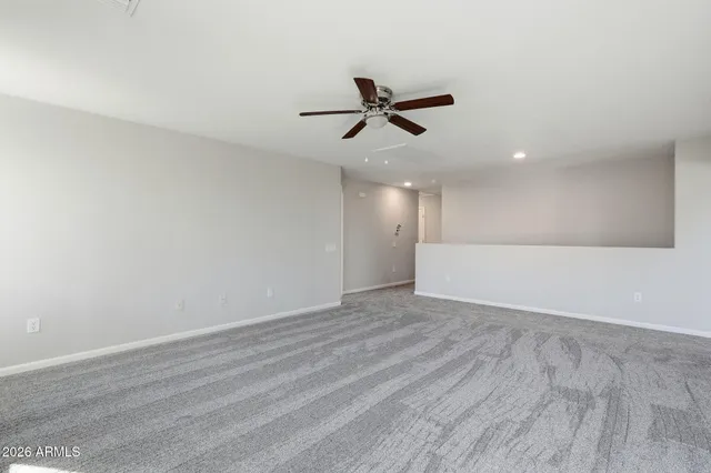 a view of room with hardwood floor and ceiling fan