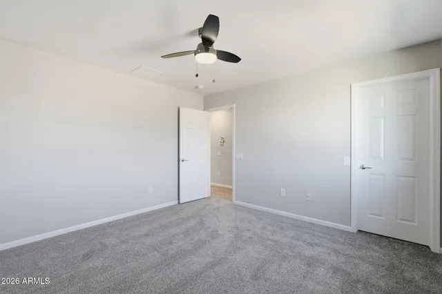 an empty room with a window and a ceiling fan