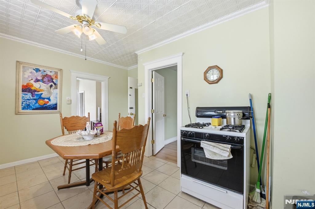 110 Tappan Street Kearny, NJ 07032 - Photo 3 of 13 a kitchen with a stove a refrigerator and a dining table