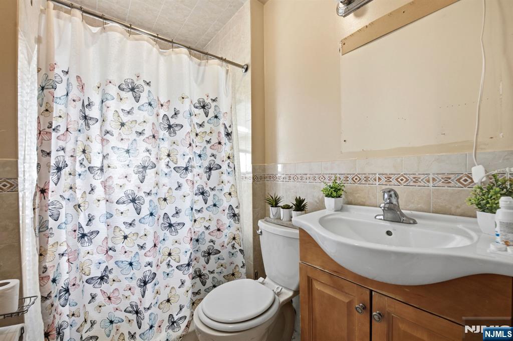 110 Tappan Street Kearny, NJ 07032 - Photo 8 of 13 a bathroom with a sink a toilet and a mirror