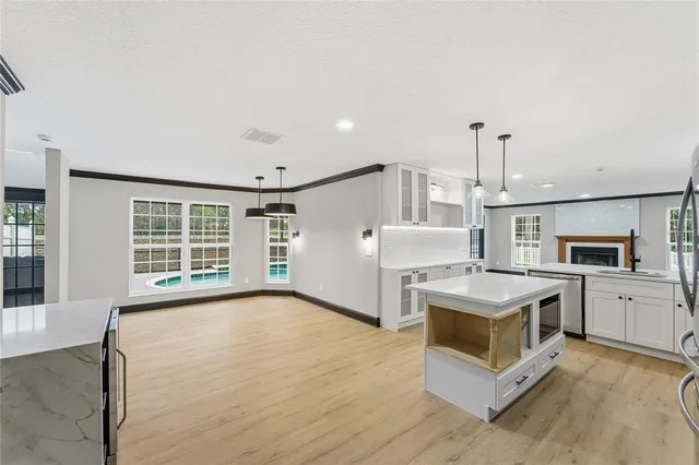 a living room with furniture a chandelier and a dining table with wooden floor