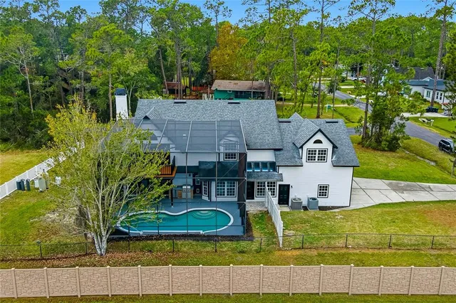 an aerial view of a house with swimming pool and garden