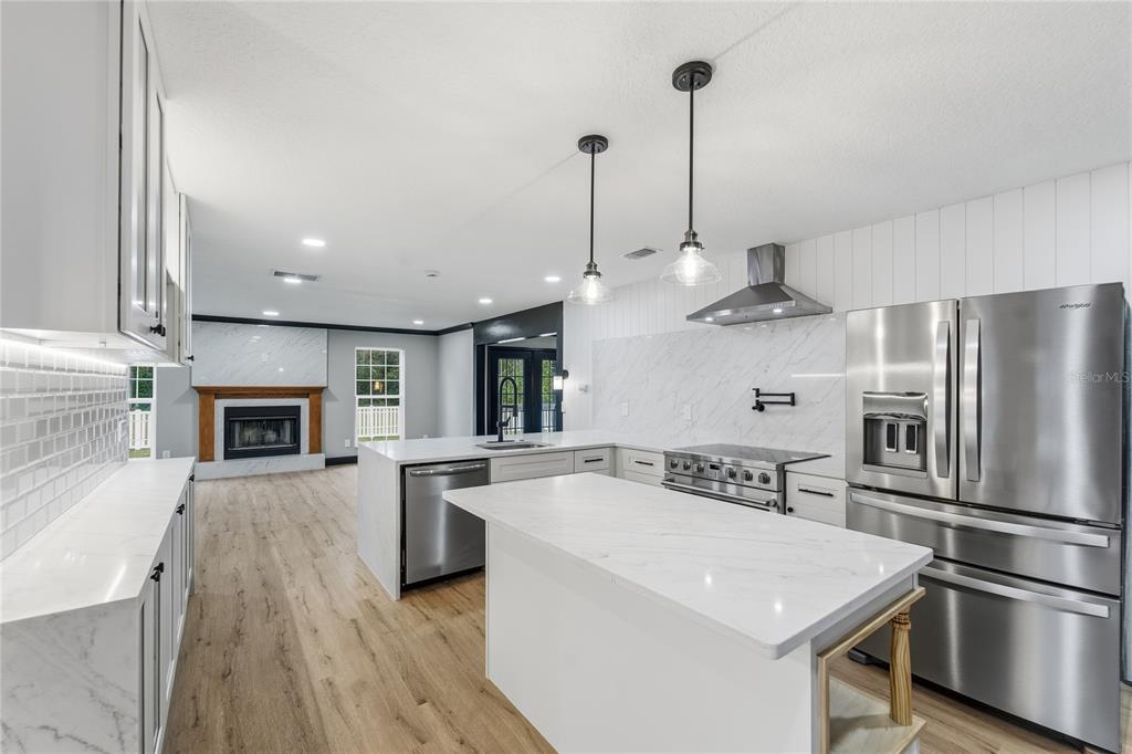 14728 Henson Road Orlando, FL 32832 - Photo 24 of 70 a kitchen with stainless steel appliances granite countertop a refrigerator a oven a sink with a countertop and chairs