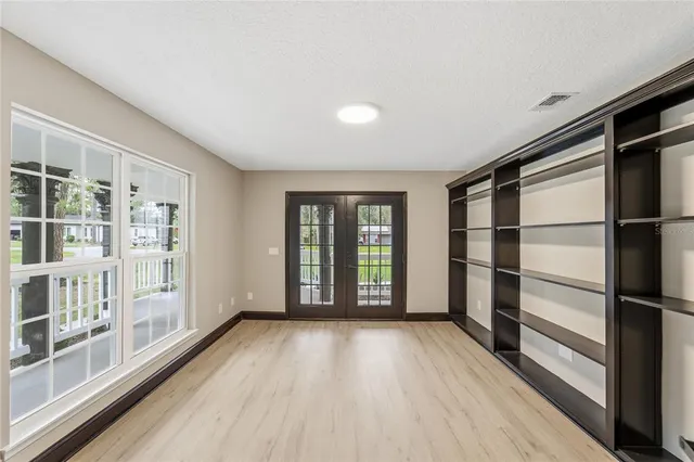 a view of an empty room with wooden floor