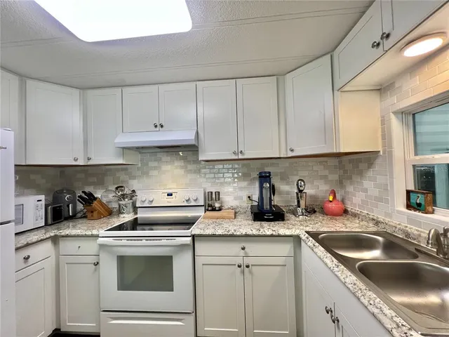 a bathroom with a granite countertop sink mirror vanity bathtub and a toilet