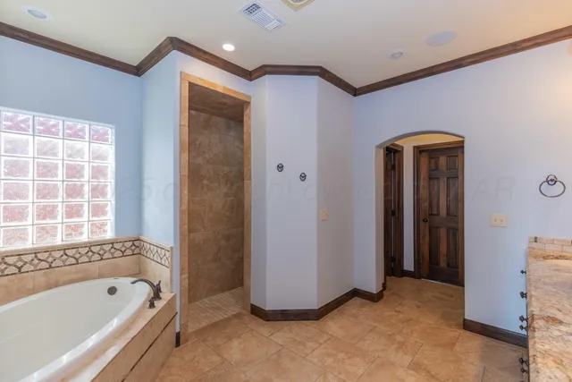 a view of an empty room with window and chandelier fan