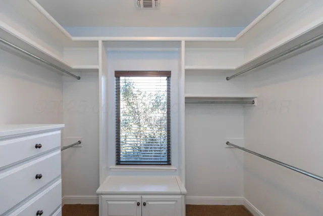 a view of a livingroom with a chandelier fan and windows