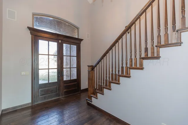 an entryway with wooden floor and stairs