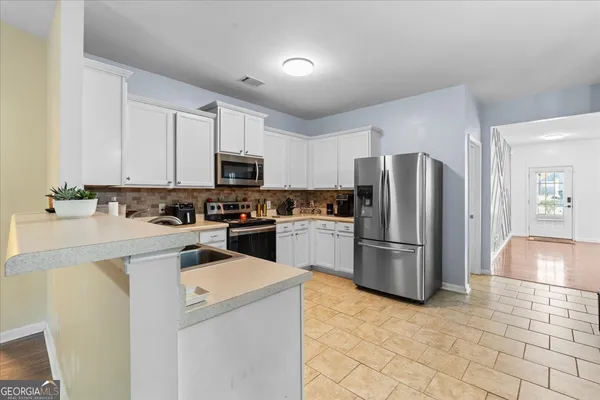 a kitchen with a refrigerator a stove top oven a counter space and a window