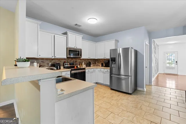 a kitchen with a refrigerator a stove top oven a counter space and a window