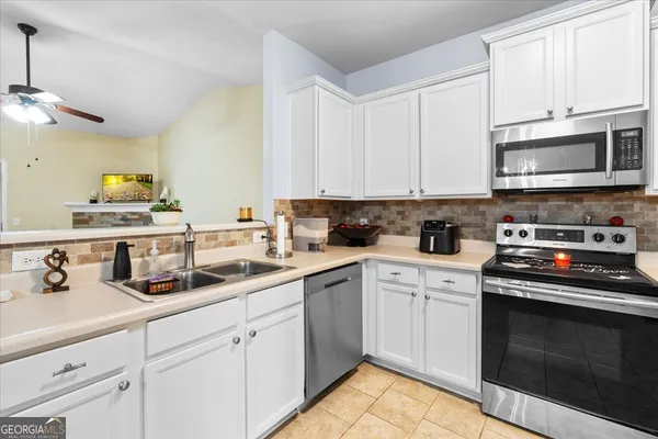 a kitchen with stainless steel appliances granite countertop a sink a stove a microwave and cabinets
