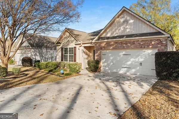 a view of a white house with a large tree in front of it