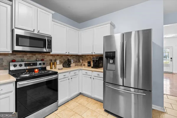a kitchen with cabinets stainless steel appliances and a window