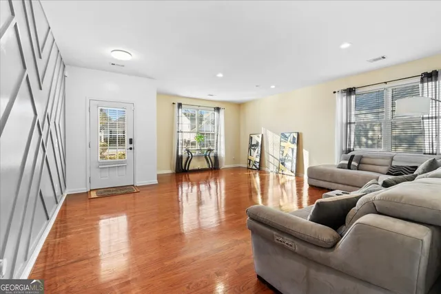 a living room with furniture and wooden floor
