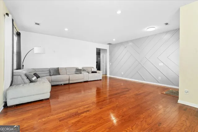 a living room with furniture and a wooden floor