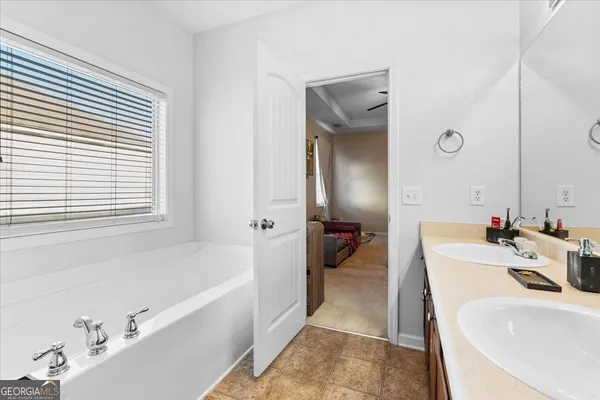 a bathroom with a tub sink and mirror