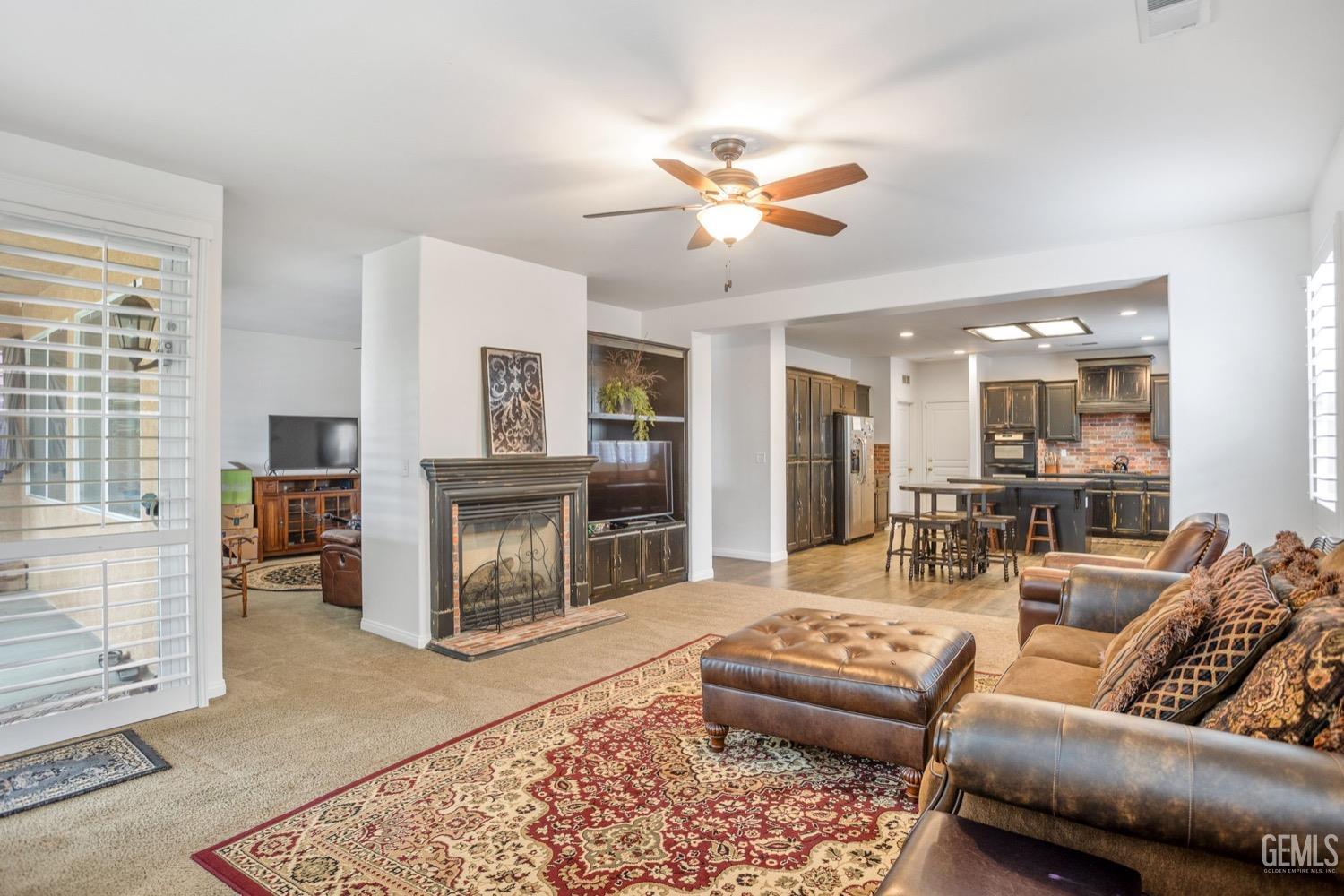 Undisclosed Address Bakersfield, CA 93312 - Photo 16 of 45 a living room with furniture a fireplace and a table