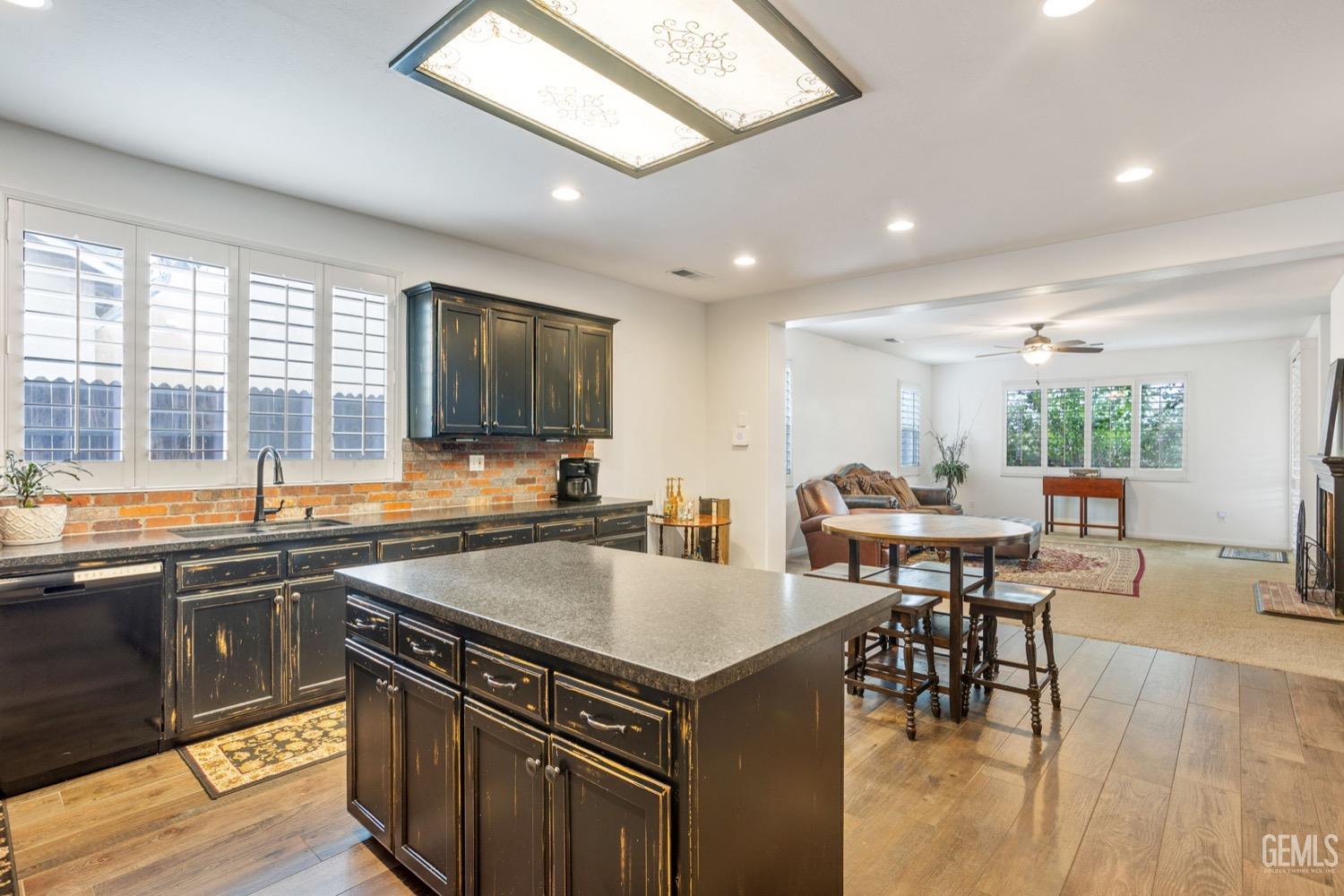 Undisclosed Address Bakersfield, CA 93312 - Photo 21 of 45 a kitchen with a stove a sink a counter top space and living room view
