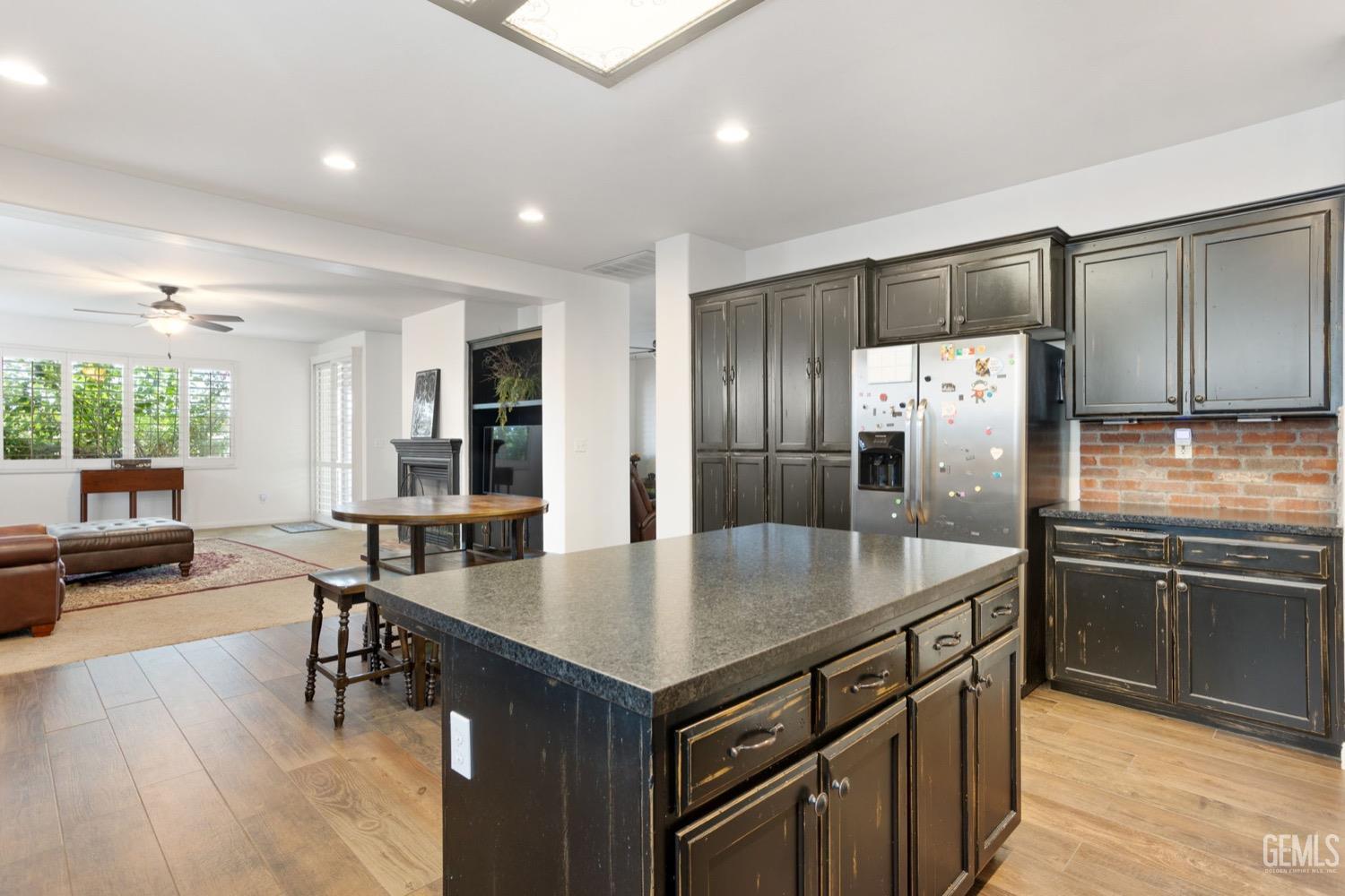 Undisclosed Address Bakersfield, CA 93312 - Photo 24 of 45 a kitchen with stainless steel appliances granite countertop a table chairs and wooden floors