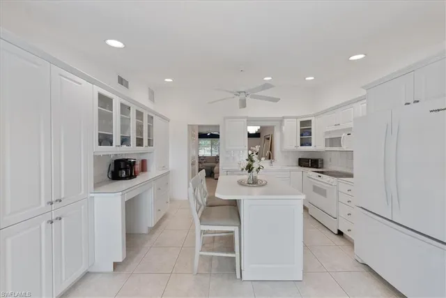 a kitchen with white cabinets and white appliances