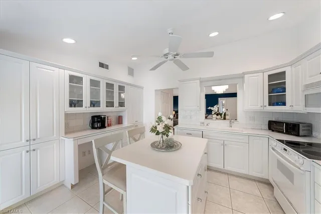 a kitchen with stainless steel appliances cabinets a dining table and chairs