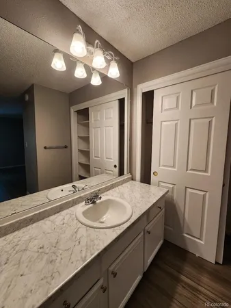 a bathroom with a granite countertop sink and a mirror