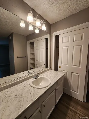 a bathroom with a granite countertop sink and a mirror