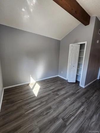 a view of empty room with wooden floor