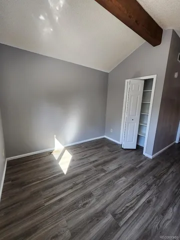 a view of empty room with wooden floor