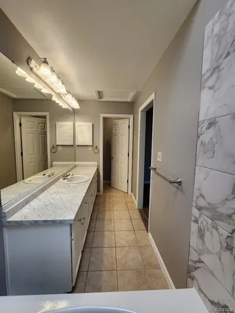 a large bathroom with a granite countertop sink a large mirror and shower