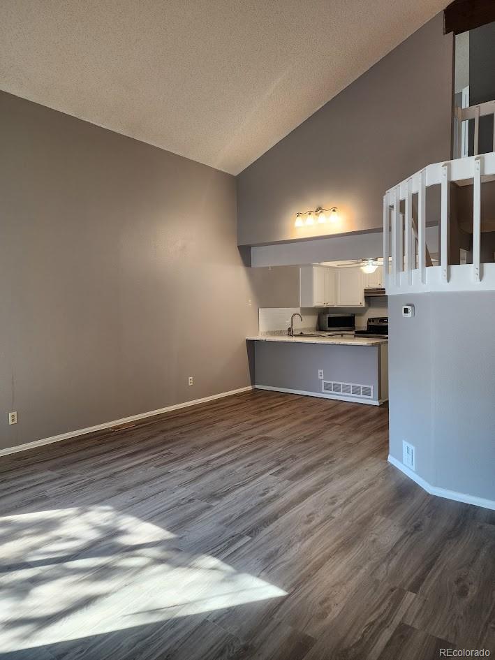 2685 South Dayton Way, Unit 365 Denver, CO 80231 - Photo 4 of 24 a view of kitchen and empty room with wooden floor