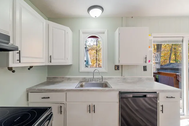 a kitchen with cabinets appliances and a window