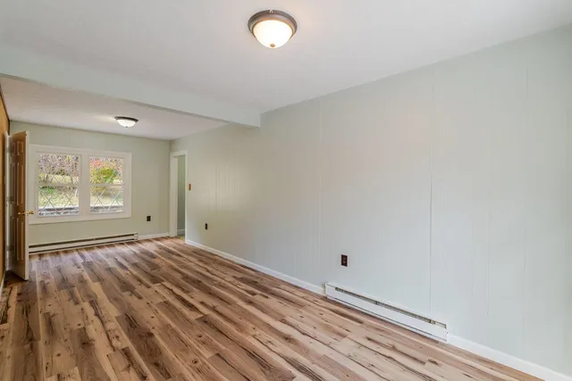 a view of room with window and wooden floor