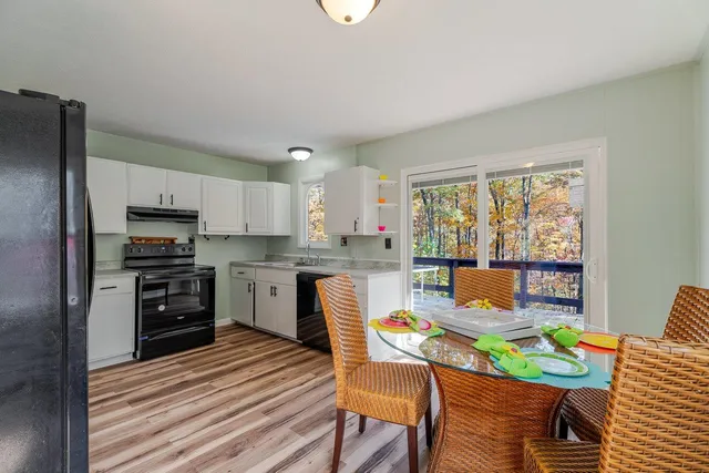 a open kitchen with a refrigerator a stove top oven a sink and cabinets