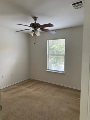 an empty room with a window and a fan