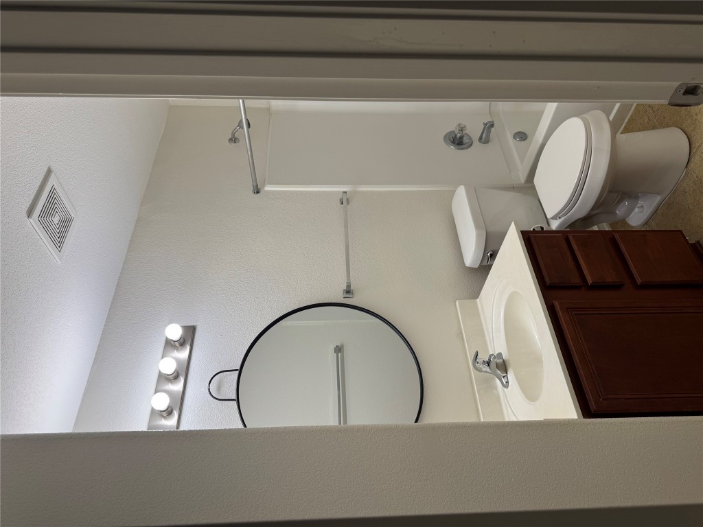 5609 Viewpoint Drive Austin, TX 78744 - Photo 19 of 21 a bathroom with a toilet a sink and mirror