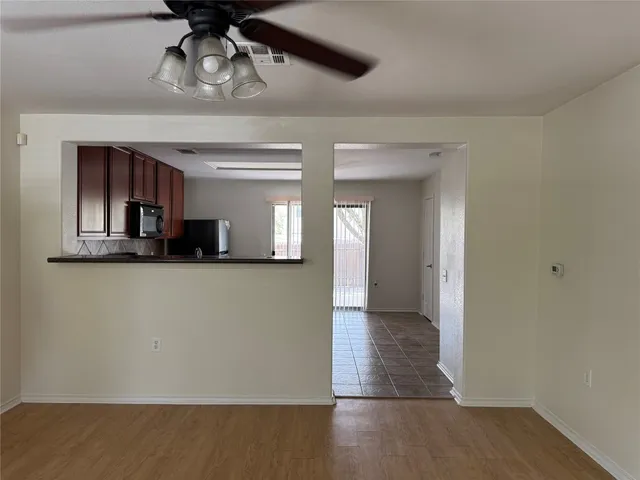 a view of a hallway with wooden floor and chandelier
