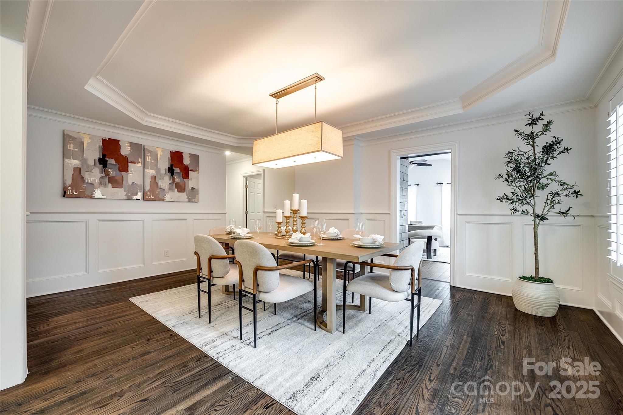 1225 Providence Road Charlotte, NC 28207 - Photo 6 of 42 a dining room with wooden floor a chandelier a wooden table and chairs
