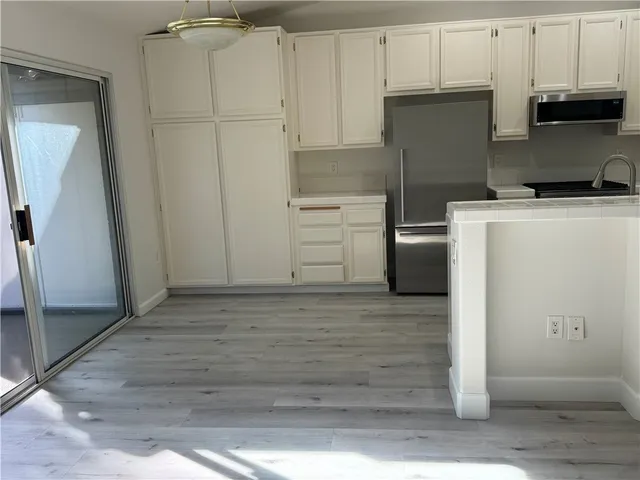 a kitchen with cabinets and stainless steel appliances