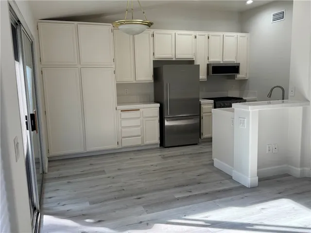 a kitchen with a refrigerator and a stove