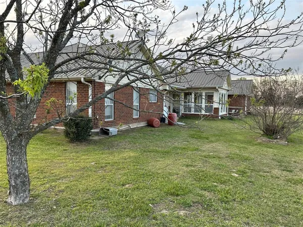 a front view of a house with a garden and trees