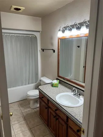 a bathroom with a granite countertop toilet and a sink