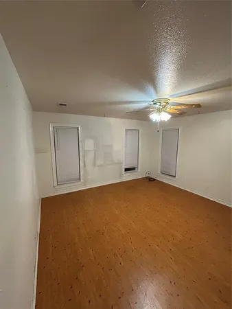 a view of an empty room with a chandelier fan