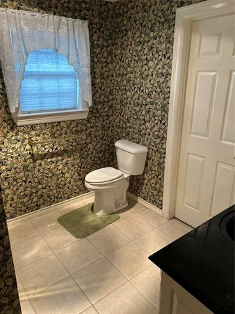 an empty room with windows and ceiling fan