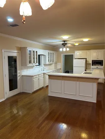 a kitchen with granite countertop white cabinets and white appliances