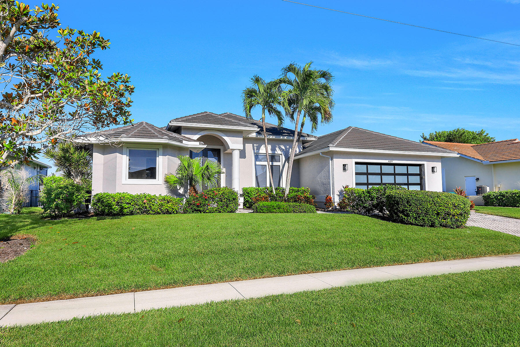 409 Waterleaf Court Marco Island, FL 34145 - Photo 38 of 38 a front view of a house with a garden