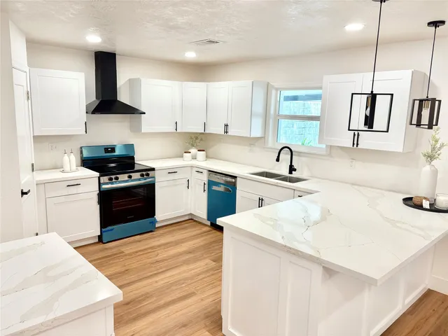 a kitchen with a sink a stove a refrigerator and white cabinets