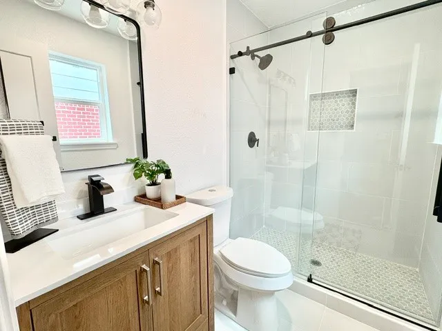 a bathroom with a sink a toilet and shower