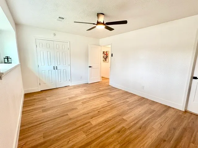 a view of empty room with wooden floor